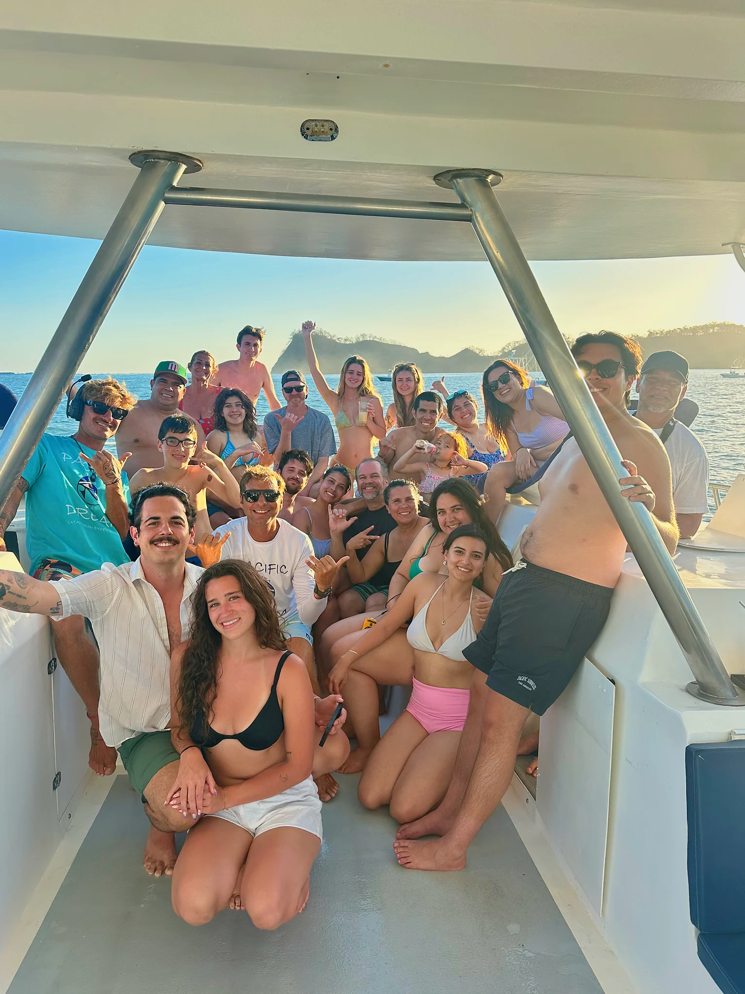 Large group under the catamaran canopy | Pacific Dream Nosara A large group of guests poses together under the shaded canopy of the catamaran.